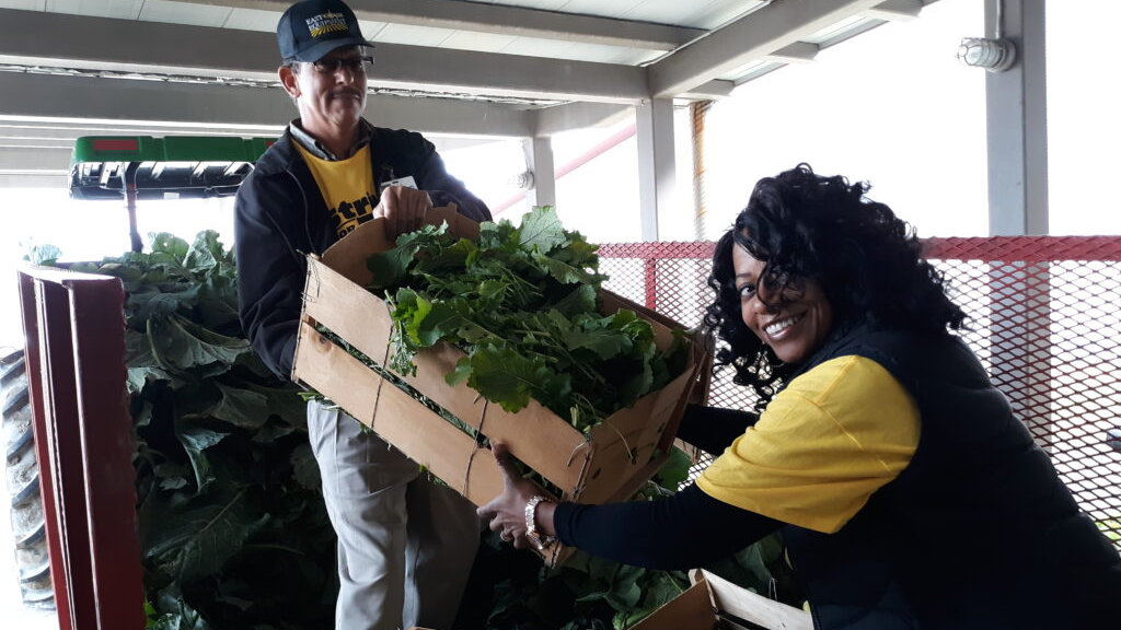 two people loading a produce box